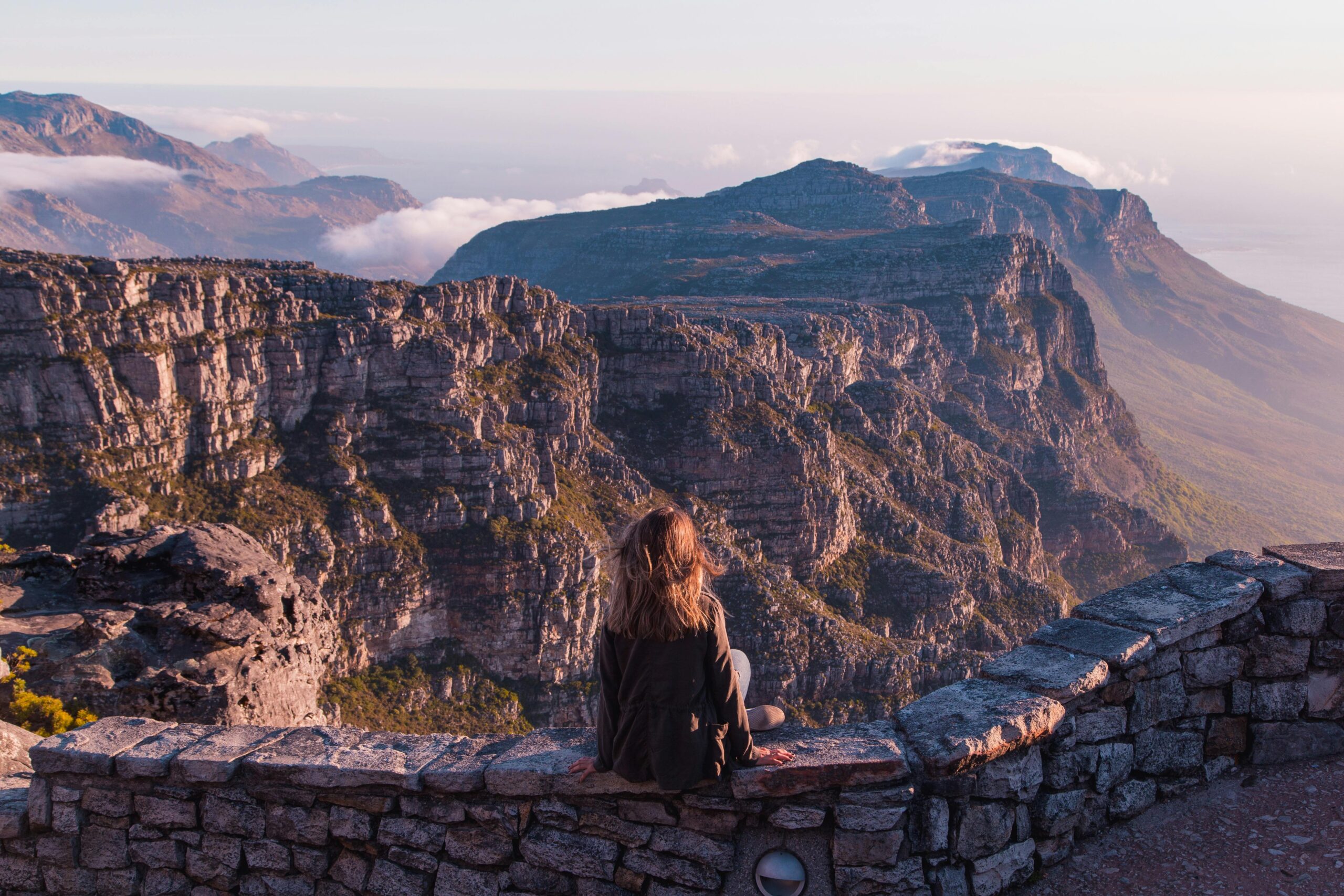 Woman sitting peacefully overlooking mountains